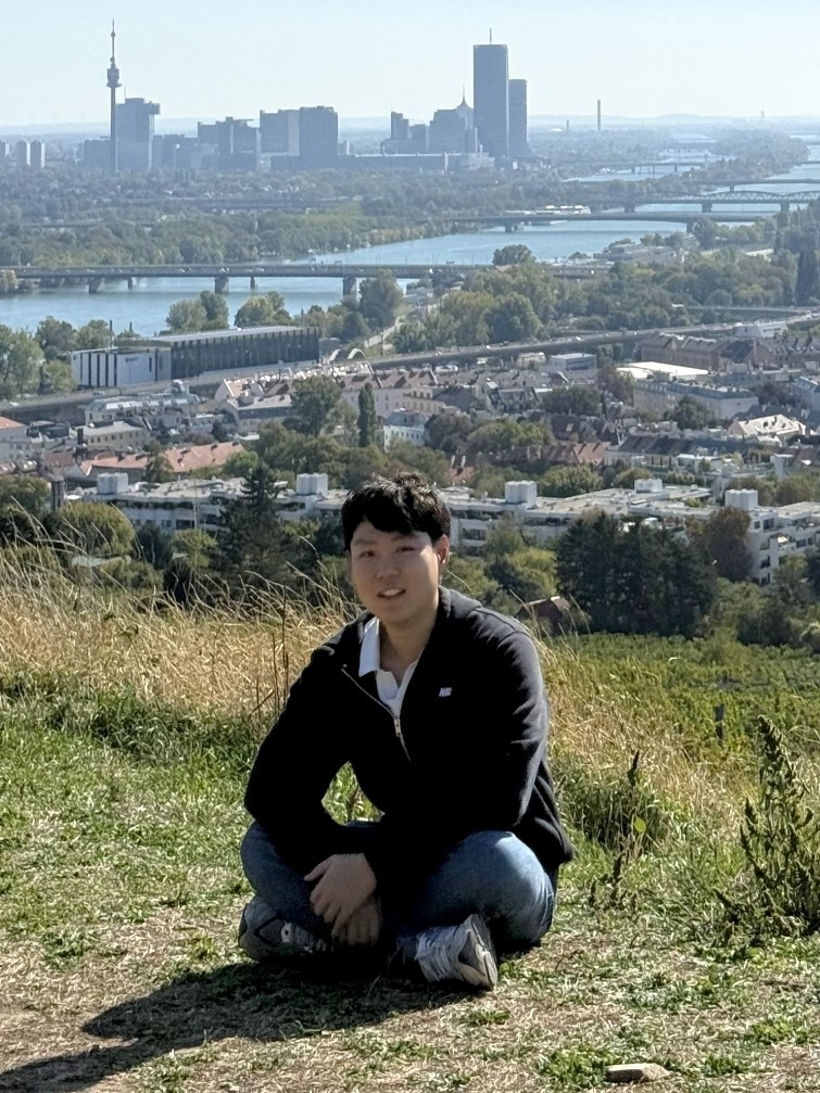 Portrait of Taewoo Kim with city skyline in the background